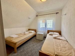 a room with two beds and a window at Planinski vuk rooms in Žabljak