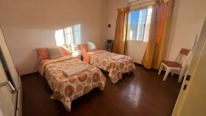 a hotel room with two beds and a window at Duplex Jauregui en Lujan in Luján