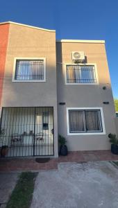 a building with three windows and a fence at Duplex Jauregui en Lujan in Luján