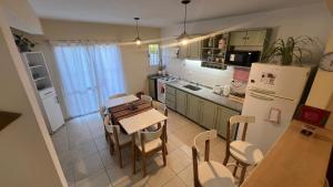 a kitchen with a table and chairs and a refrigerator at Duplex Jauregui en Lujan in Luján
