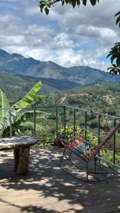 a bench sitting on a patio with a table and mountains at Casa Vista Cafe in Cartago