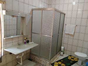 a bathroom with a shower and a sink and a toilet at Quartos da Cida in Foz do Iguaçu +12 photos
