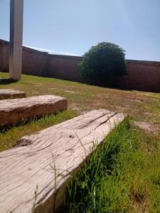 a large rock in the grass next to a fence at Mi casa es tu casa Loft in Malargüe +1 photo