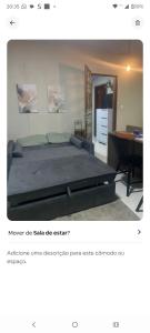 a bedroom with a large bed and a desk at Condominio Central Charmoso in Uruguaiana