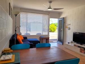 a living room with a blue couch and a tv at Baccarat in Port Vincent