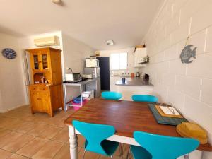 a kitchen with a wooden table and blue chairs at Baccarat in Port Vincent