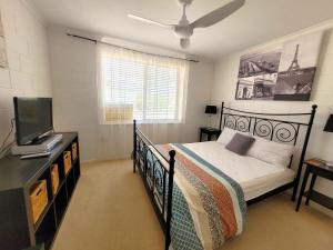 a bedroom with a bed and a flat screen tv at Baccarat in Port Vincent