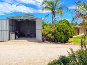 a garage with a palm tree and a house at Baccarat in Port Vincent