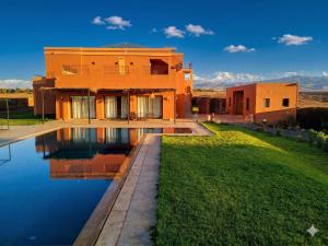 a house with a swimming pool in front of it at Bab Sma in Oumnas