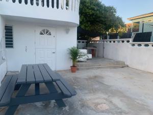 a picnic table in front of a white house at Kelly's Vacation Nest to Relax and Reactivate in Willemstad