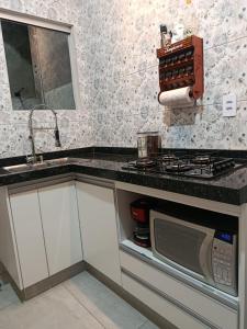 a kitchen with a sink and a microwave at Espaço jr in Andradina