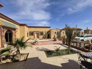a house with a car parked in a courtyard at Riad Berber in Merzouga