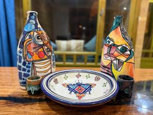 three vases sitting next to a plate on a table at Oualidia surflodge in Oualidia