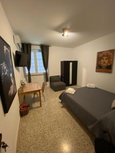 a bedroom with a bed and a chair and a table at BERNOCCHI ROMA APARTMENT, difronte metropolitana in Acilia