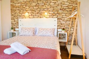 a bedroom with a bed with a stone wall at Relax Natural en Vigo Rural Mos con Jacuzzi y Vistas in Mos