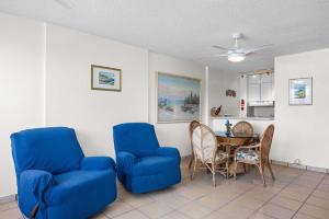 a living room with blue chairs and a table at Playa Azul Beach by Otium in Luquillo +31 photos