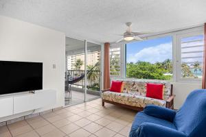 a living room with a couch and a flat screen tv at Playa Azul Beach by Otium in Luquillo