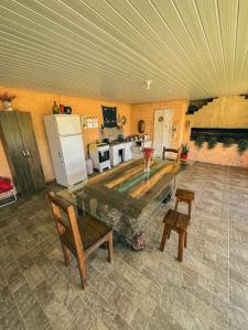 a living room with a table and a kitchen at Pousada e Camping São Matheus in Lauro Müller