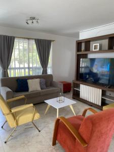 a living room with a couch and a tv at Casa Verbena in Cisneros
