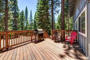 a wooden deck with a grill and a chair on it at Carnelian Bay Lake House in Carnelian Bay