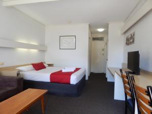 une chambre d'hôtel avec un lit, un canapé et une télévision dans l'établissement Kingston Lobster Motel, à Kingston South East