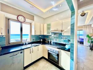 a large kitchen with a clock on the wall at 360 Oceanfront & Sunset View Condo - Terrace & 2BR in Tangier