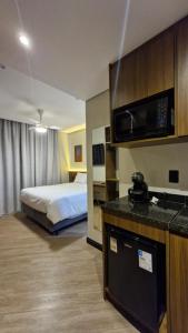 a hotel room with a bed and a microwave at Nexus Conceição in São Paulo
