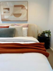 a bedroom with a bed with a painting on the wall at CBD Apartment, Sleeps 4 with Free Car Park in Melbourne