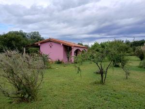 a small pink house in the middle of a field at Casas de Epoca -Limerencia in Charbonier
