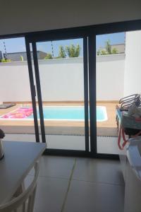 a view of a swimming pool through a window at Casa Completa e Funcional in Sinop