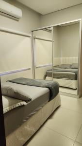 two beds in a room with a mirror at Casa Completa e Funcional in Sinop