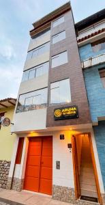 a building with orange doors and a sign on it at Aruma Andina Hotel CHAVÍN in Chavín de Huantar