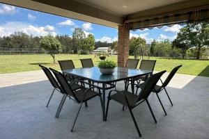 a black table and chairs on a patio at Marignano Homestead in Broke