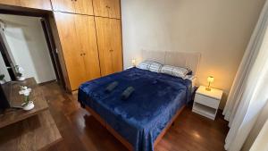 a bedroom with a bed with a blue comforter at Amplo apartamento completo no Centro Cambuí in Campinas