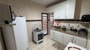a kitchen with a refrigerator and a stove in it at Amplo apartamento completo no Centro Cambuí in Campinas