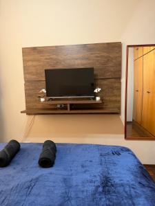 a bedroom with a flat screen tv on a wall at Amplo apartamento completo no Centro Cambuí in Campinas