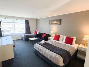 a hotel room with a bed and a couch at Champers Motor Inn in Lower Hutt +28 photos