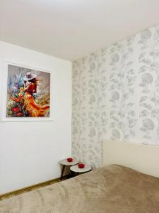a bedroom with a bed and a painting on the wall at Sweet Home in Kosovo Polje