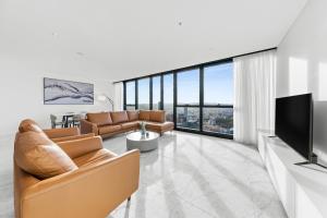 a living room with a couch and a television at CLLIX Brisbane Skytower Apartments in Brisbane
