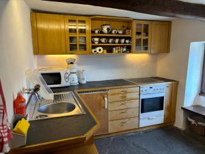 a small kitchen with a sink and a microwave at Rustico Bellavista in Mergoscia
