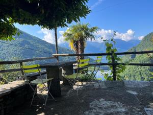 a table and chairs with a view of mountains at Rustico Bellavista in Mergoscia +19 photos
