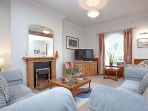 a living room with a fireplace and blue chairs at Tuckenhay, Turbine Cottage - Fkd in Ashsprington +47 photos