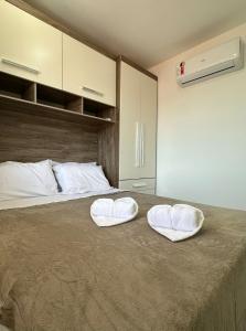 two white towels sitting on top of a bed at Piratininga a Beira Mar - Niterói in Niterói