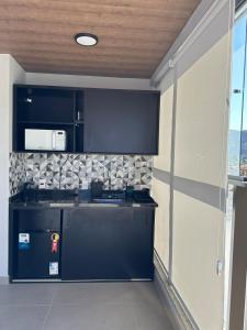a kitchen with black cabinets and a counter top at Piratininga a Beira Mar - Niterói in Niterói