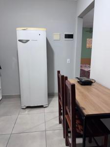 a refrigerator in a room with a wooden table at Casa aconchegante in Timbó