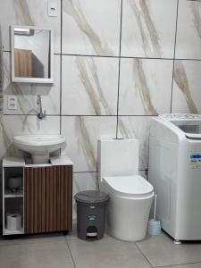 a bathroom with a toilet and a sink at Casa aconchegante in Timbó