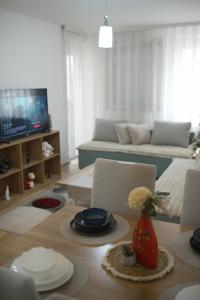 a living room with a table with chairs and a couch at Sweet Home in Kosovo Polje