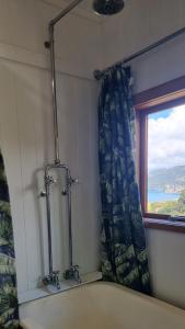 a bathroom with a window and a shower curtain at The Rock in Tuateawa +42 photos