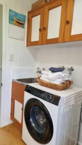 a washing machine in a kitchen with a sink at The Rock in Tuateawa