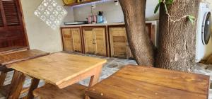 a kitchen with two wooden tables and a tree at Mộc House in Ninh Hải